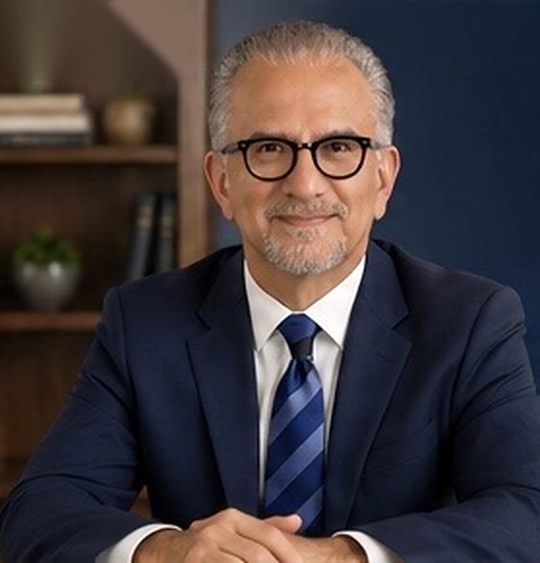 Portrait of Michael, host of GRIP Financial Planning, in a navy suit with a blue striped tie